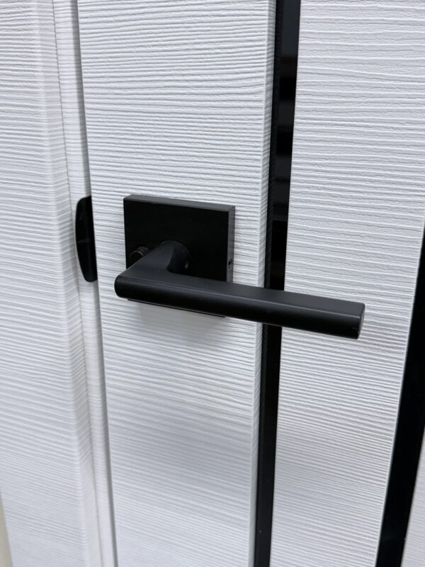 Matte black lever handle on a square rosette on a white textured interior door