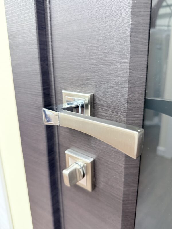 Satin nickel lever handle and privacy thumbturn on a grey interior door